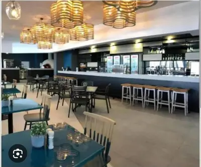 a restaurant with tables and chairs and a bar at The Bylde Crystal Lagoon Apartment in Pretoria
