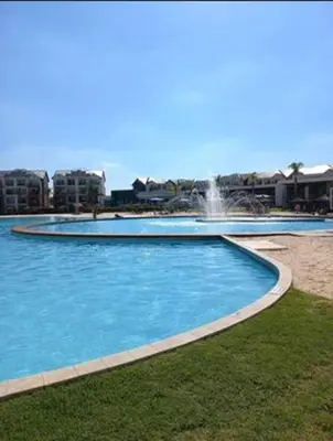 a large blue swimming pool with a fountain at The Bylde Crystal Lagoon Apartment in Pretoria