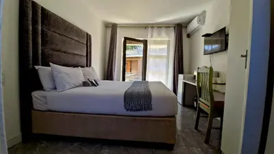 a bedroom with a bed and a desk with a computer at 7 Heaven Boutique Hotel in Burgersfort