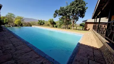 a large pool of blue water next to a building at 7 Heaven Boutique Hotel in Burgersfort