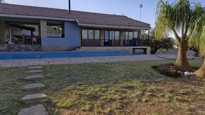 a house with a palm tree in the yard at 7 Heaven Boutique Hotel in Burgersfort