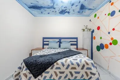 a bedroom with a bed in a room with a ceiling at Monoshez in Benoni