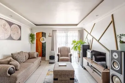 a living room with a couch and a tv at Monoshez in Benoni