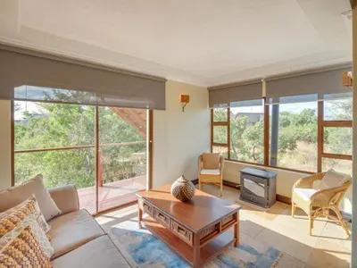 a living room with a couch and a table at 210 Zebula, 5-bedroom house & 1-bedroom cottage in Warmbaths