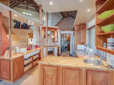 a large kitchen with wooden cabinets and a sink at 210 Zebula, 5-bedroom house & 1-bedroom cottage in Warmbaths