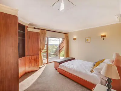 a bedroom with a large bed and a large window at 210 Zebula, 5-bedroom house & 1-bedroom cottage in Warmbaths