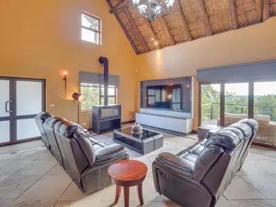 a living room with leather couches and a tv at 210 Zebula, 5-bedroom house & 1-bedroom cottage in Warmbaths