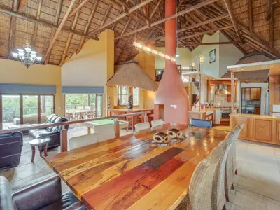 a large living room with a wooden table and a kitchen at 210 Zebula, 5-bedroom house & 1-bedroom cottage in Warmbaths