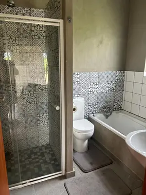 a bathroom with a shower and a toilet and a sink at Dinokeng Bush Cabin in Hammanskraal
