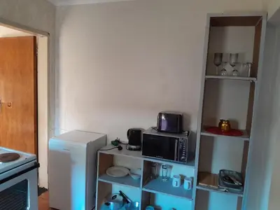 a small kitchen with a microwave and a refrigerator at Cozy in Centurion