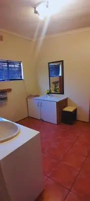 a bathroom with a sink and a mirror on the wall at Cozy in Centurion