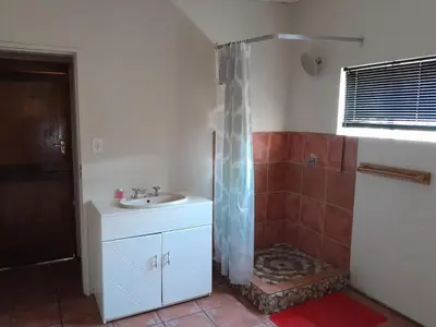 a bathroom with a shower curtain and a sink at Cozy in Centurion