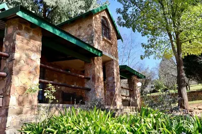 a stone building with a green roof at Tall Trees in Dullstroom