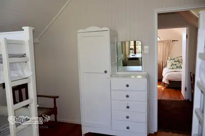 a bedroom with a white dresser and a mirror at Tall Trees in Dullstroom