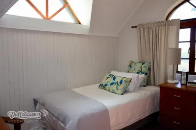 a bedroom with a bed with pillows and a window at Tall Trees in Dullstroom