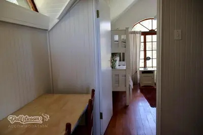 a dining room with a table and a kitchen at Tall Trees in Dullstroom
