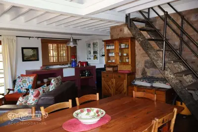 a living room and dining room with a spiral staircase at Tall Trees in Dullstroom