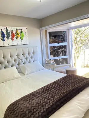 a bedroom with a large white bed and a window at Cosy Room steps from the lake- short term stay in Benoni
