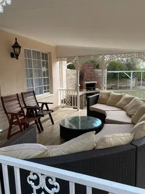 a living room with a couch and a table at Cosy Room steps from the lake- short term stay in Benoni
