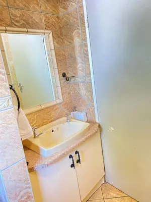 a bathroom with a sink and a mirror at Cosy Room steps from the lake- short term stay in Benoni