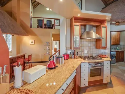 a kitchen with a counter top with a stove at 210 Zebula, 5-bedroom villa in Warmbaths