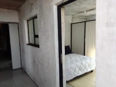 a bedroom with a white bed in a room at Mokoena Village guesthouse in Akasia