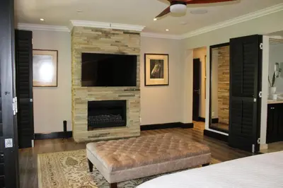 a living room with a fireplace and a tv at South Lawn Boutique Horse Hotel in Midrand