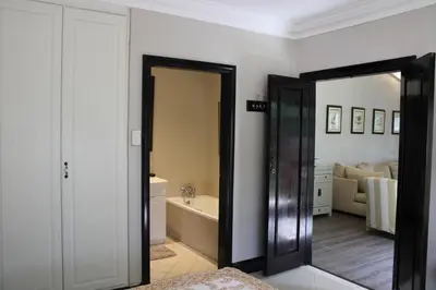 a bathroom with a mirror and a tub in a room at South Lawn Boutique Horse Hotel in Midrand