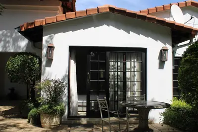 a small white house with a table and a patio at South Lawn Boutique Horse Hotel in Midrand
