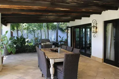 a patio with a wooden table and chairs at South Lawn Boutique Horse Hotel in Midrand