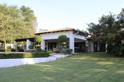 a white house with a lawn in front of it at South Lawn Boutique Horse Hotel in Midrand