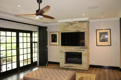 a living room with a fireplace and a flat screen tv at South Lawn Boutique Horse Hotel in Midrand