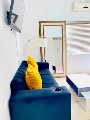 a blue couch with yellow pillows in a living room at Genza Guesthouse in Pretoria in Pretoria