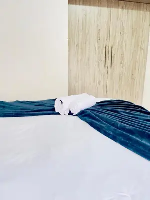 a bed with two towels sitting on top of it at Genza Guesthouse in Pretoria in Pretoria