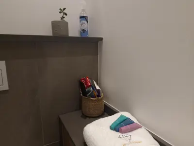 a bathroom with a towel and a basket of toothbrushes at Emerald Studio Menlyn Maine in Pretoria