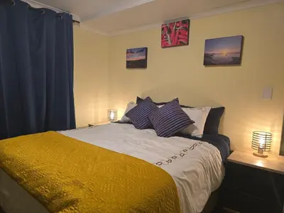 a bedroom with a bed with pillows and two lamps at Private Garden Studio near Menlyn in Pretoria