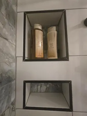two bottles ofodorizers sitting on a shelf in a bathroom at Private Garden Studio near Menlyn in Pretoria