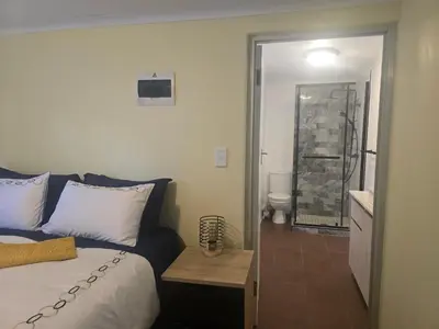 a bedroom with a bed and a bathroom with a toilet at Private Garden Studio near Menlyn in Pretoria
