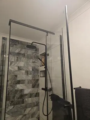 a shower in a bathroom with a stone wall at Private Garden Studio near Menlyn in Pretoria