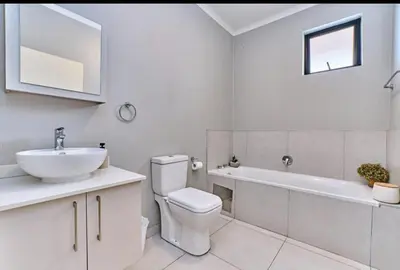 a bathroom with a toilet and a sink and a tub at Unit 235 at 50 On Lever in Midrand