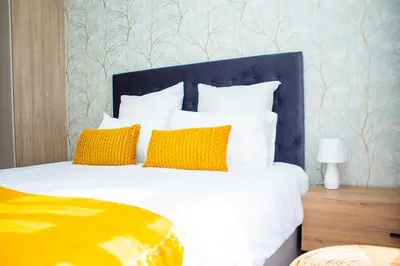 a bedroom with a large bed with yellow pillows at Unit 235 at 50 On Lever in Midrand