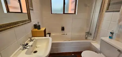 a bathroom with a sink and a toilet and a tub at Acacia at Greenway Woods in White River