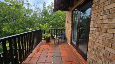 a balcony with a table and chairs on it at Acacia at Greenway Woods in White River