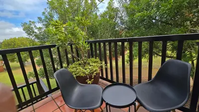 two chairs and a table on a balcony at Acacia at Greenway Woods in White River