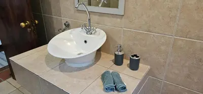 a bathroom with a sink on a counter with towels at Boabab at Greenway Woods in White River