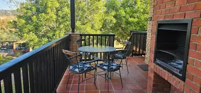 a patio with a table and chairs on a balcony at Boabab at Greenway Woods in White River
