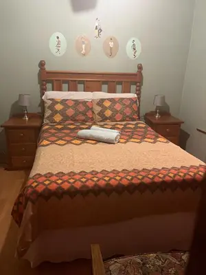 a bedroom with a bed with two nightstands and two lamps at EvehomeStay B&B in Soshanguve