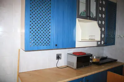 a kitchen with blue cabinets and a microwave on a counter at EvehomeStay B&B in Soshanguve