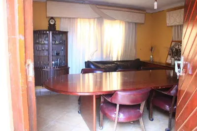 a dining room with a wooden table and chairs at EvehomeStay B&B in Soshanguve