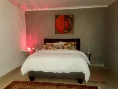 a bedroom with a bed with pink lights on it at GenAyah Hotel & Safari in Mtimba
